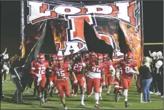  ?? DAVID WITTE/NEWS-SENTINEL ?? Lodi players burst through a sign before the start of Lodi's game against Bear Creek on Friday at the Grape Bowl.