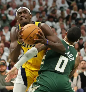  ?? Stacy Revere/Getty Images ?? Indiana’s Pascal Siakam, left, forces his way around Milwaukee’s Damian Lillard in the first half of Game 2 of an Eastern Conference playoff series in Milwaukee.