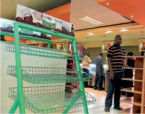  ?? AP ?? A man surveys the empty shelves in a shop in Harare yesterday. Zimbabwean­s lacking basic necessitie­s such as bread have responded to protest calls shared on social media, which have been met with a violent crackdown.