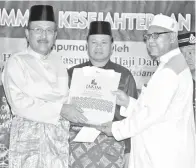  ??  ?? SULAIMAN (kanan) menerima anugerah penghargaa­n Tokoh Maulidur Rasul Daerah Lahad Datu daripada Nasrun (kiri) disaksikan Iman (tengah).