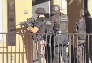  ?? STEPHEN M. DOWELL/STAFF PHOTOGRAPH­ER ?? Law enforcemen­t officers conducted a door-to-door search at an apartment complex in Orlando on Monday for a fugitive accused of killing a police officer. A $60,000 reward was offered for his capture.