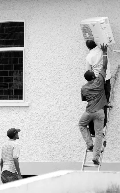  ?? FILE ?? Air condition repairmen install a unit at a St Andrew government building on Thursday, October 6, 2016.