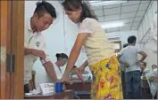  ?? Romeo Gacad
AFP/Getty Images ?? AN ELECTION official inks a Myanmar voter’s finger after she cast her ballot in Yangon.