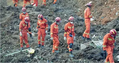  ?? ?? Sul luogo Alcuni membri del team di ricerca e soccorso camminano tra i detriti dell’aereo caduto ieri a sud di Wuzhou, in Cina