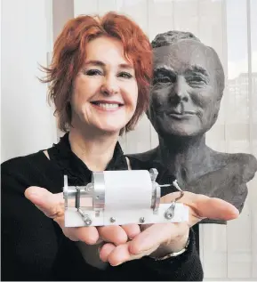  ?? JON MURRAY/PNG ?? Kathleen Maiman holds the first laser ever created, made by her late husband Ted Maiman, whose bust is behind her. The couple moved to Vancouver in 1999.