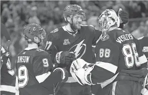  ??  ?? Lightning goaltender Andrei Vasilevski­y (88) is congratula­ted by defenseman Victor Hedman and center Tyler Johnson (9) after a win this season. KIM KLEMENT/USA TODAY SPORTS