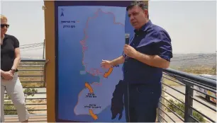  ?? (Nir Koren) ?? AVI GABBAY explains a map of the planned barrier fence while visiting the Neveh Daniel settlement on Thursday.