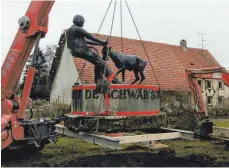  ?? FOTO: AXEL BEUTNER ?? Nicht „auf de schwäb’sche Eisebahne“, aber sicher verzurrt verlässt die Skulptur „Geißbock und Bauer“ihren alten Standort, um in Bälde am Bahnhofspl­atz eine neue Heimat zu finden.