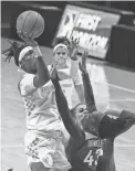  ?? RANDY SARTIN/USA TODAY SPORTS ?? Tennessee guard Rennia Davis, middle, goes to the basket against Arkansas guard Makayla Daniels, bottom, on Thursday in Knoxville, Tenn.