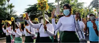  ?? Agence France-presse ?? ↑
Protesters hold sunflowers during a demonstrat­ion against the military coup in Dawei on Wednesday.