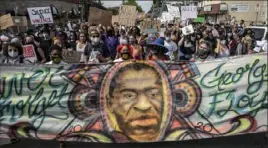  ?? Victor J. Blue/The New York Times ?? Marchers carry a banner depicting George Floyd during a June 6 protest in Minneapoli­s.