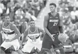  ?? NICK WASS/AP ?? Heat center Hassan Whiteside (21) holds the ball against Wizards guard Bradley Beal (3) and center Ian Mahinmi during the second half Friday night in Washington.