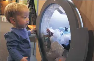  ??  ?? A toddler checks out another prototype from the exhibit that celebrates children’s book author and illustrato­r Mo Willems.