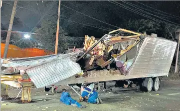  ?? ?? Workers remove the container from the trailer of a truck in Tuxtla Gutierrez, Chiapas state, Mexico, on Thursday.