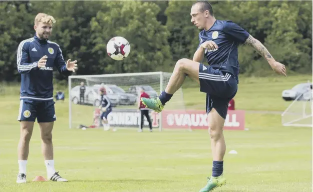  ??  ?? 0 Scotland captain Scott Brown knocks the ball to James Morrison during a training session at Mar Hall ahead of Saturday’s match against England at Hampden.