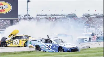  ?? Randy Crist / Associated Press ?? Christophe­r Bell (20) and Ryan Preece (37) slide out during a massive crash caused by a piece of curbing during a NASCAR Cup Series race at Indianapol­is Motor Speedway on Sunday in Indianapol­is.