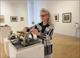  ?? JENNIE BLEVINS — ENTERPRISE-RECORD ?? Museum of Northern California Art Executive Director Pat Macias plays with artist Alice Hutchins' steel sculpture “Repulsion” Friday at the museum in Chico.