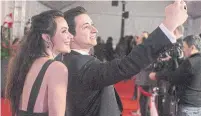  ?? CHRIS YOUNG THE CANADIAN PRESS ?? Figure skaters Tessa Virtue and Scott Moir take red carpet selfie as they are inducted into the 2018 Canada Walk of Fame.