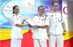  ??  ?? Dr Chan (centre) hands over the Platinum Award to MRC Serian and teacher-in-charge of MRC SMK Serian Unit, Phang. Looking on at right is MRC Sarawak director Chai King Sing.