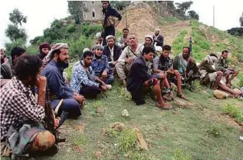 ??  ?? Pro-government fighters sit in a village they retook from Iran-allied Al Houthi militia in the Al Sarari area of Taiz province in Yemen on Thursday.