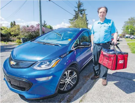  ?? DARREN STONE, TIMES COLONIST ?? Bill Cox, a Skip the Dishes driver, has a Chevrolet Volt electric vehicle which, he says, allows him to continue to do more lengthy deliveries without having to worry about high fuel costs.
