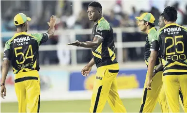  ?? IAN ALLEN/PHOTOGRAPH­ER ?? Members of the Jamaica Tallawahs team congratula­te Oshane Thomas (centre) after one of his wickets against the St Kitts and Nevis Patriots at Sabina Park on Wednesday night.