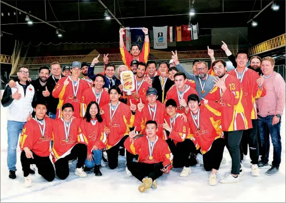  ?? PHOTOS BY XINHUA ?? Team China players and officials celebrate after defeating Spain 4-1 to win the Division II Group A title at the 2022 IIHF Men’s World Championsh­ip in Zagreb, Croatia, on April 30. The triumph secured China a spot in Division I Group B after an absence of 15 years.