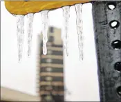  ?? MIKE SIMONS / TULSA WORLD VIA ASSOCIATED PRESS ?? Icicles form on a street sign in downtown Bartlesvil­le, Oka., on Friday. A winter storm is descending on the southern Plains and Midwest, dumping treacherou­s freezing rain.