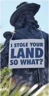  ?? Picture: DAVID RITCHIE ?? PROTEST: Community activist Suleiman Stellenboo­m hung placards on colonialis­t statues in the Cape Town CBD including this statue of Jan van Riebeeck.