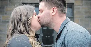  ?? CLIFFORD SKARSTEDT EXAMINER ?? Taylor Eddie shares a kiss with her fiancé Taylor Lauzon outside their home in Douro-Dummer Township. The pair have postponed their June 6 wedding to next year due to the pandemic.