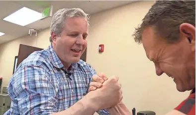  ?? AP PHOTOS ?? Robert Baxter arm wrestles Spencer Lightningf­ire in his South Jordan, Utah, office on Nov. 15. Baxter is up to his neck in competitio­n in both the restaurant business and the world of arm wrestling, but says facing off against rivals has brought him...