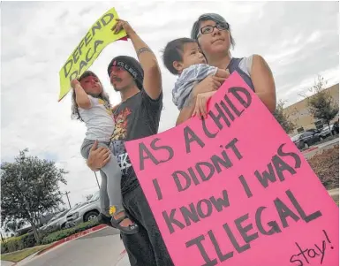  ?? Nathan Lambrecht / AP ?? Kathia Ramírez (der.), de 24 años, sostiene a su hijo Rowen Salinas, de 11 meses, mientras su esposo Randy Salinas tiene en sus brazos a su hija Fridah Salinas, de dos años, durante una protesta por el DACA en Pharr, Texas.