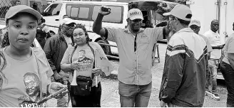  ?? ?? Lloyd Gillings (centre), People’s National Party candidate for the Albert Town division in Trelawny Southern, gestures while interactin­g with supporters.
