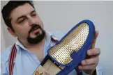  ??  ?? Antonio Vietri shows a man shoe as part of his collection "Gold" in his workshop in Turin.