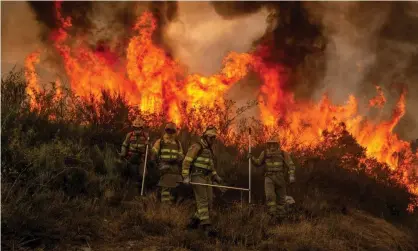  ??  ?? Firefighte­rs battle a forest fire in Galicia, northern Spain on Thursday as temperatur­es soar across southern Europe. Photograph: Brais Lorenzo/EPA