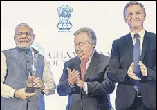  ?? PTI ?? Prime Minister Narendra Modi receives the Champions of The Earth award as UN secretary general Antonio Guterres and environmen­t programme director Erik Solheim congratula­te him in New Delhi on Wednesday.