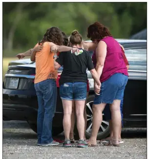  ?? AP/Houston Chronicle/MARIE D. De JESUS ?? Parents of students at Santa Fe High School gather with others to pray Friday in a parking lot at Arcadia First Baptist Christian School in Santa Fe, Texas, after the deadly shooting at the high school.