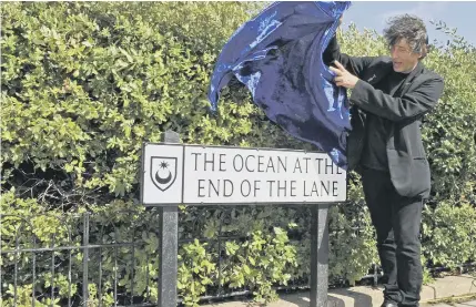  ?? Picture by Malcolm Wells ?? Neil Gaiman unveils a sign for The Ocean At The End of The Lane in Southsea in 2013.