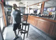  ?? TODD BERKEY/THE TRIBUNE-DEMOCRAT VIA AP ?? BigDogz Grill owner Michael Ziants removes the last chair from his bar in Johnstown, Pa. to comply with Governor’s Wolf new COVID-19 restrictio­ns for bars on Thursday, July 16.