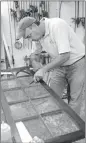  ??  ?? Schoenbaue­r Furniture Service manager Tony Chaffee works on replacing an antique pane of glass in a cabinet door. The Charlotte Hall business is celebratin­g 25 years.