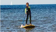  ?? Foto: Simone Steinhardt, dpa ?? Henry hat schon Übung im Stehpaddel­n. Er weiß, dass man gerade auf dem Meer vor  sichtig sein sollte.