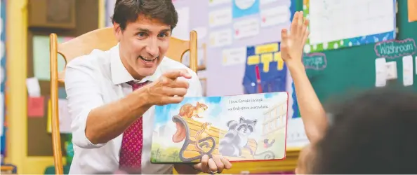  ?? GEOFF ROBINS/AFP/GETTY IMAGES ?? Liberal Leader Justin Trudeau reads a story to Grade 1 and 2 students at a campaign stop at Blessed Sacrament Catholic Elementary School in London, Ont., on Monday.