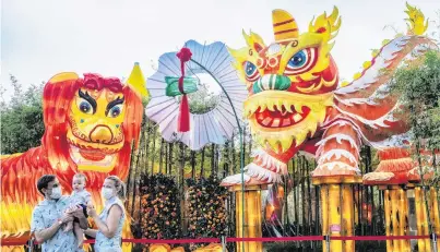  ?? PHOTO: REUTERS ?? Welcoming change . . . A family poses in front of a lantern display depicting traditiona­l Northern and Southern Chinese lion dance costumes during the annual River Hongbao festival on the eve of the Chinese Lunar New Year of the Ox, otherwise known as the Spring Festival, at Singapore's Gardens by the Bay.