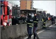  ?? AP/DANIELE BENNATI ?? Firefighte­rs and police officers stand Wednesday near the gutted remains of a bus that the driver set aflame near Milan, Italy.