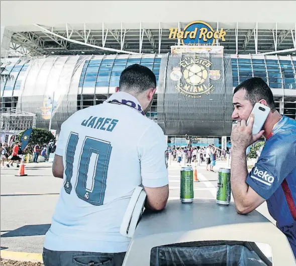  ??  ?? Dos aficionado­s en los alrededore­s del estadio de Miami, donde se disputó un amistoso entre Barça y Madrid en el verano del 2017