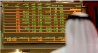  ?? — AFP ?? An investor monitors stock market activity at the Dubai Financial Market. The index fell 1.24 per cent on Sunday.