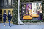  ?? AP PHOTO/MARY ALTAFFER ?? Black Friday shoppers wear face masks as the leave Saks Fifth Avenue flagships store empty-handed Friday in New York.