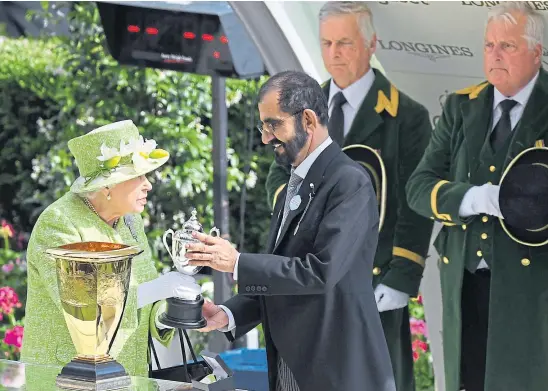  ??  ?? AWARD: The Queen presents the sheikh with a trophy after his horse won the Diamond Jubilee Stakes at Royal Ascot in 2019.
