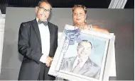  ??  ?? Sharon Snape, longest serving employee of Lannaman &amp; Morris Shipping Limited, presents chairman of the company, Harriat Maragh, with a portrait of himself.