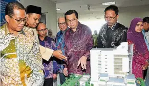  ??  ?? Model port: Mohamed Khaled (left), liow (fifth from left) and officials looking at a replica of the Port Authority building in Pasir Gudang.